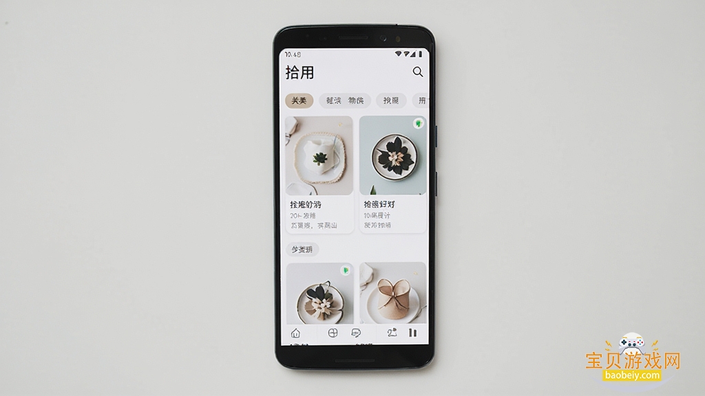 手机屏幕展示生活好物分享应用界面,主体为一部竖放的安卓手机,布局居中,排版干净,风格清新简约,细节包括好物卡片和分类标签,画质清晰,画面干净无多余元素,图中文字为