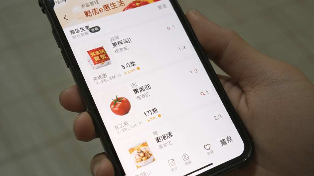 手机屏幕展示蜀信e惠生活商户商品管理界面,白色背景,界面简洁,商品列表清晰,画质干净